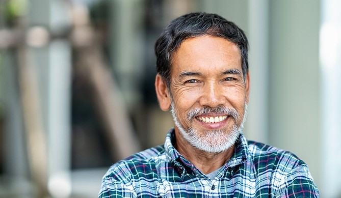 Man smiling after bone regeneration treatment