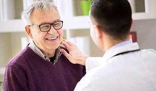 Patient smiling at dentist during consultation for All-On-4 dental implants in San Antonio