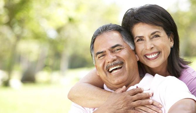 Smiling couple with All-On-4/ Pro Arch dental implants in San Antonio