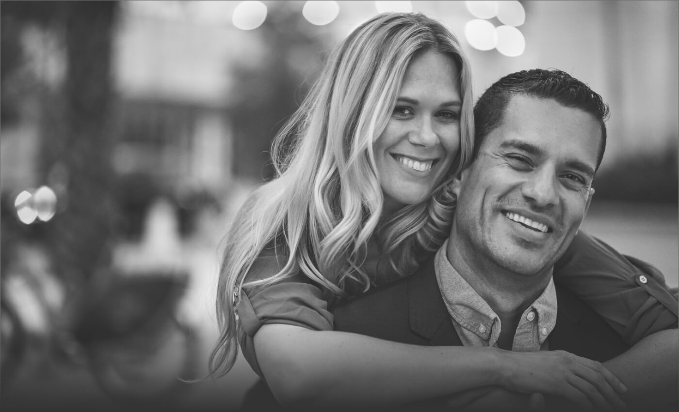 Younger man and woman smiling after periodontal treatment