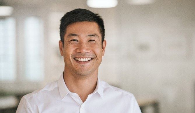 Man with dental implants in San Antonio, TX smiling in office