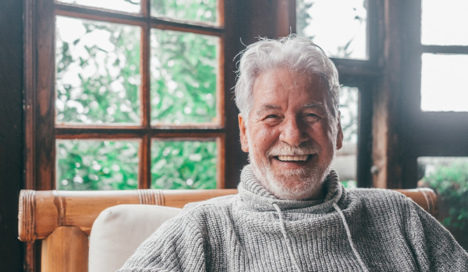 Older man in cabin smiling with dental implants in San Antonio, TX