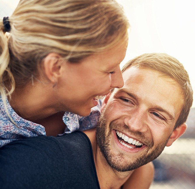 Man and woman with flawless smiles after periodontal aesthetic treatment