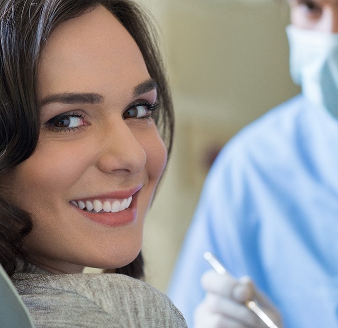 A young woman sitting in the dentist’s chair and smiling in preparation for undergoing a frenectomy to release her lip and tongue tie in San Antonio