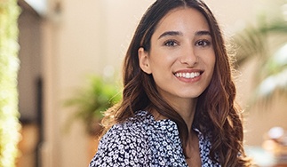 Woman with dental implants in San Antonio, TX standing and smiling