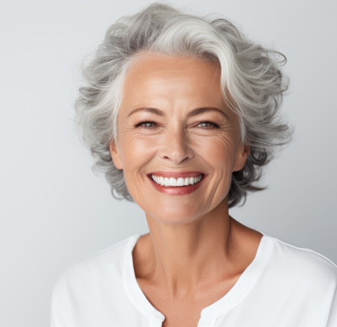 Smiling, mature woman with implant dentures in San Antonio
