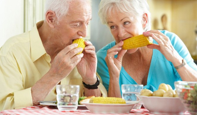Senior couple eating corn on the cob