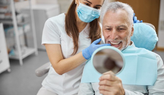 a person looking in the mirror and smiling in a dental chair