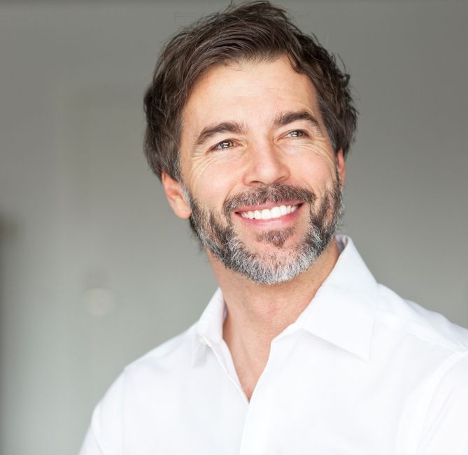 Man smiling after dental implant tooth replacement