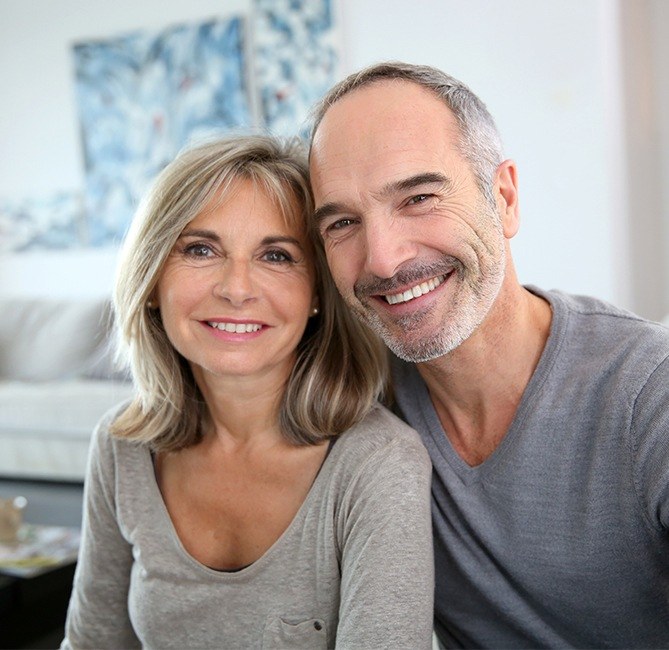 Man and woman smiling after periodontal therapy