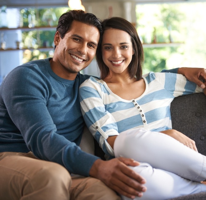 Man and woman smiling after completing periodontal services