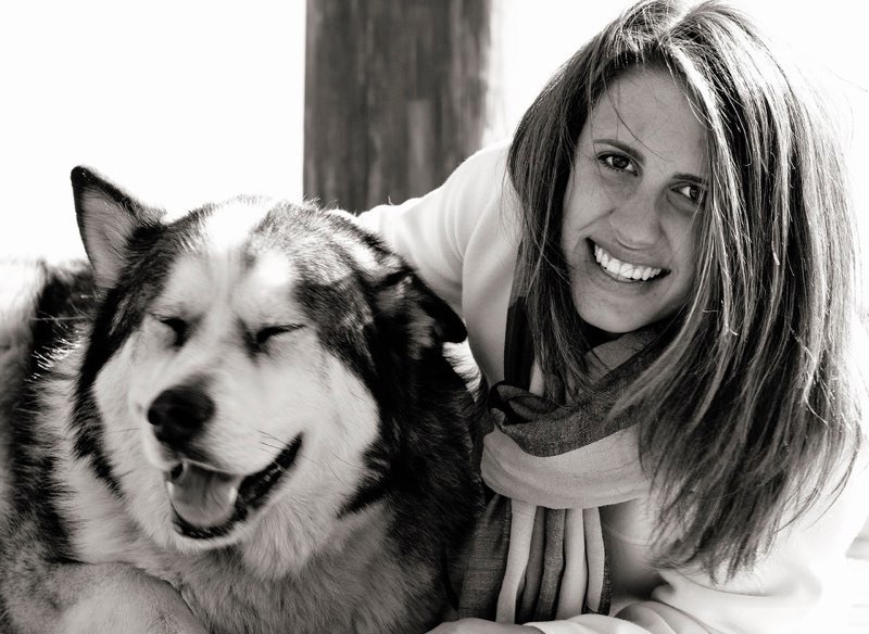 Patient with her dog smiling after tooth replacement