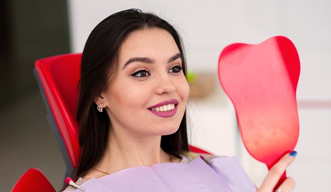 Woman looking at smile in mirror