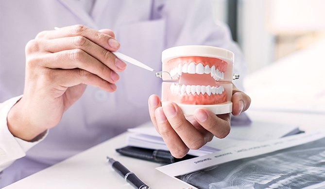 Periodontist showing patient a smile model