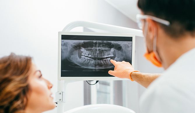 Periodontist and patient looking at x-rays