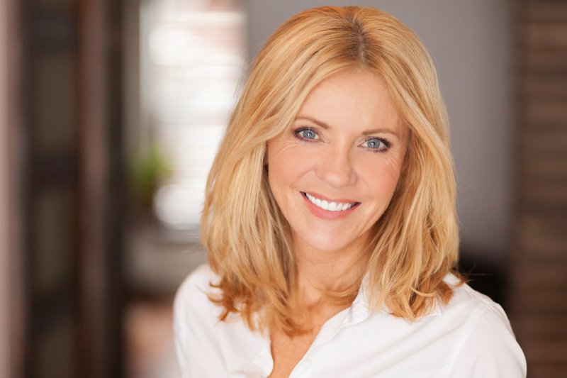 Woman smiling after receiving gum disease therapy