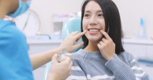 young woman smiling in dentist chair 