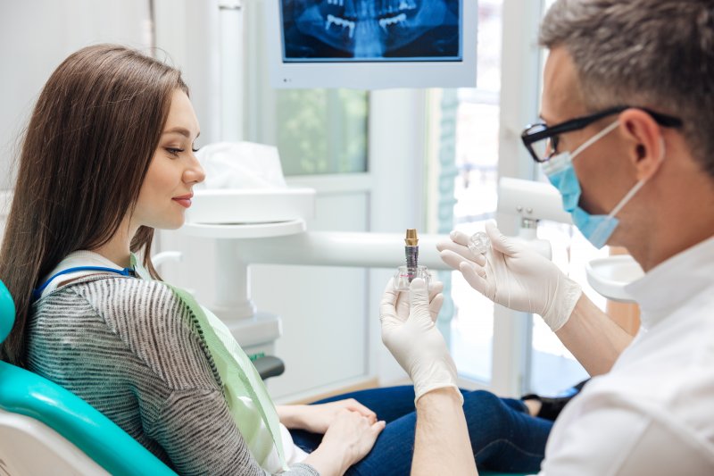 dentist explaining a dental implant to his patient